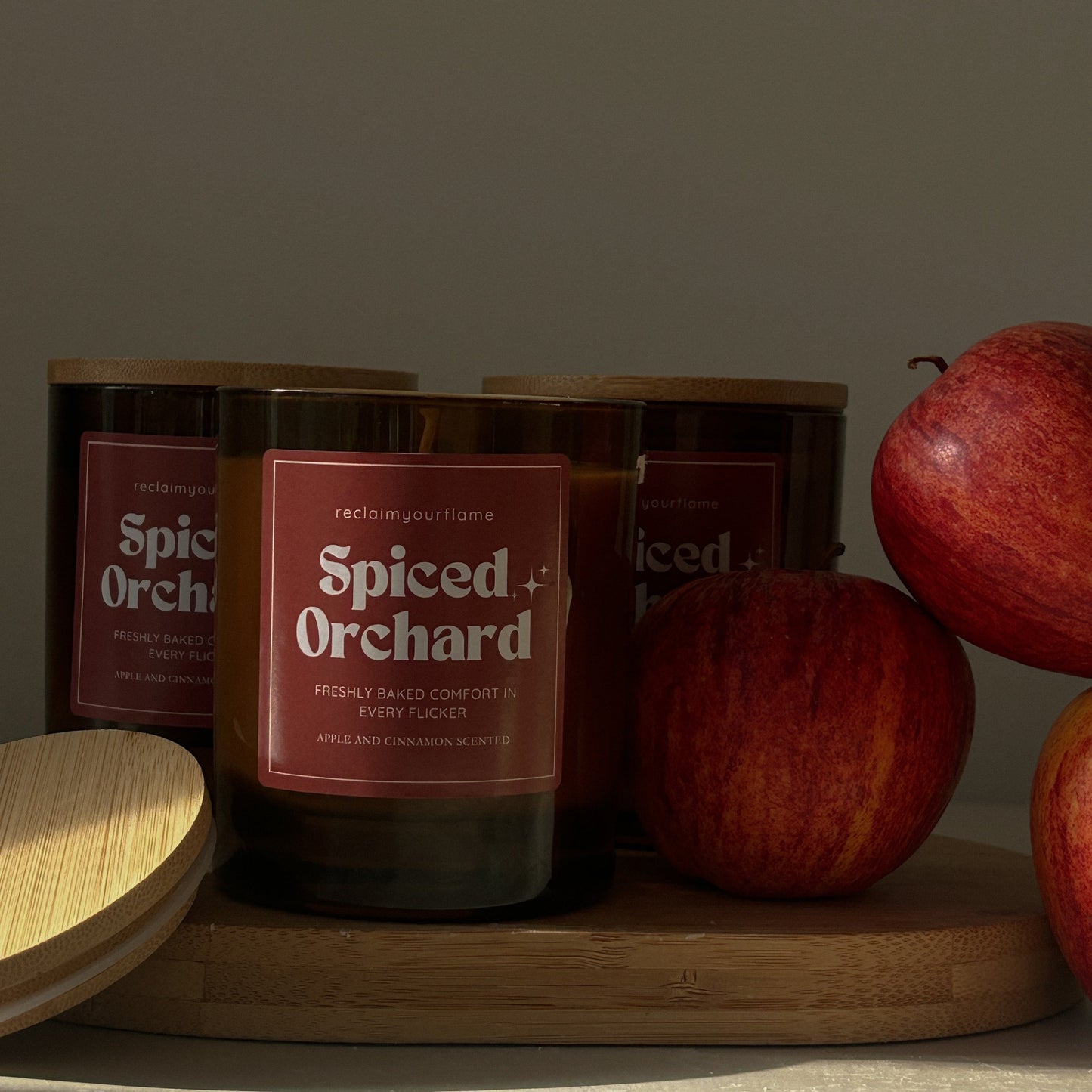 Spiced Orchard candles on a wooden surface with apples